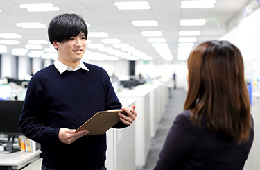 写真：同僚と話す西澤さん