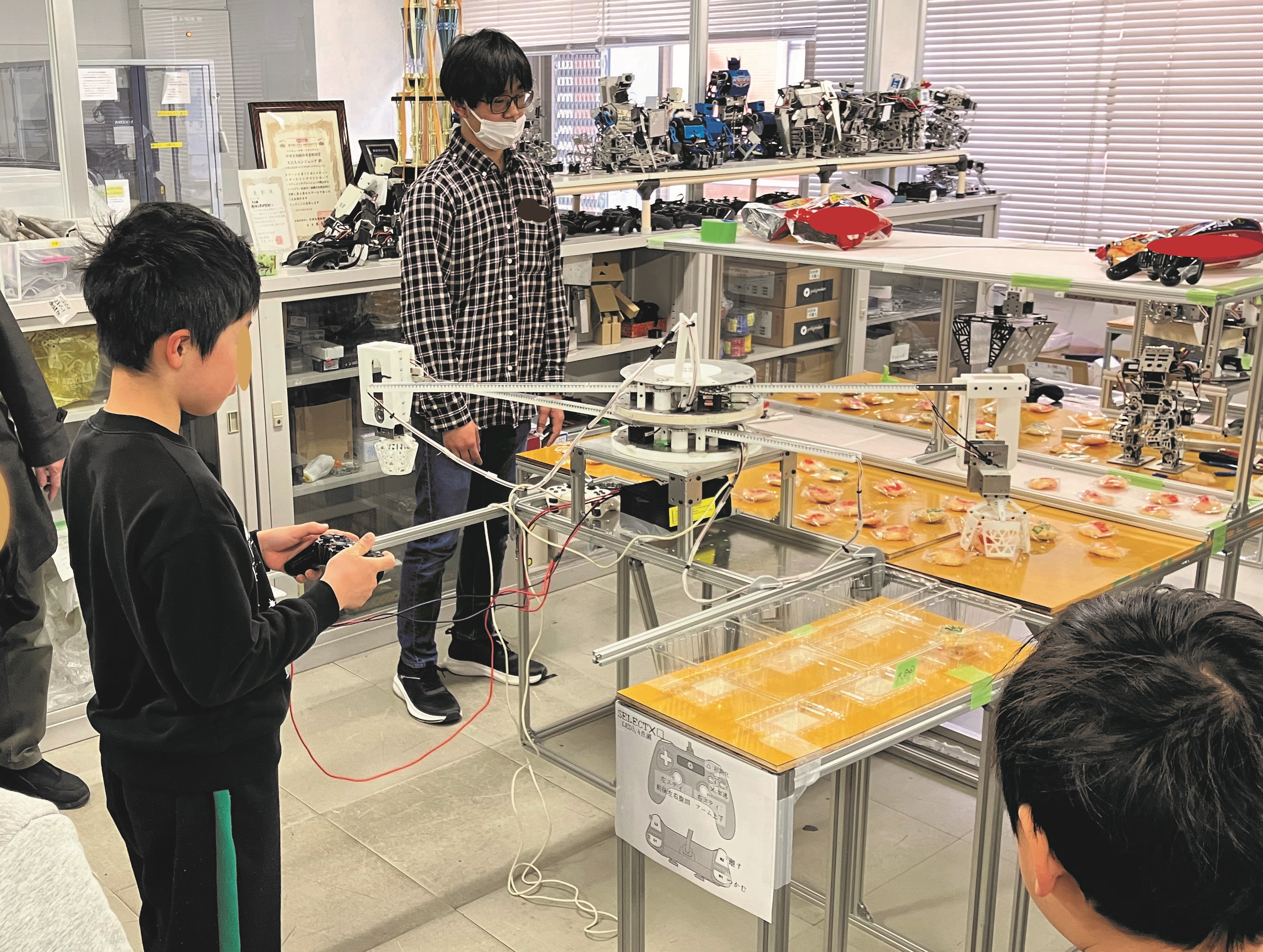 キャチロボでお菓子を掴み空き箱まで運ぶ体験をゲームのように楽しんでもらいました